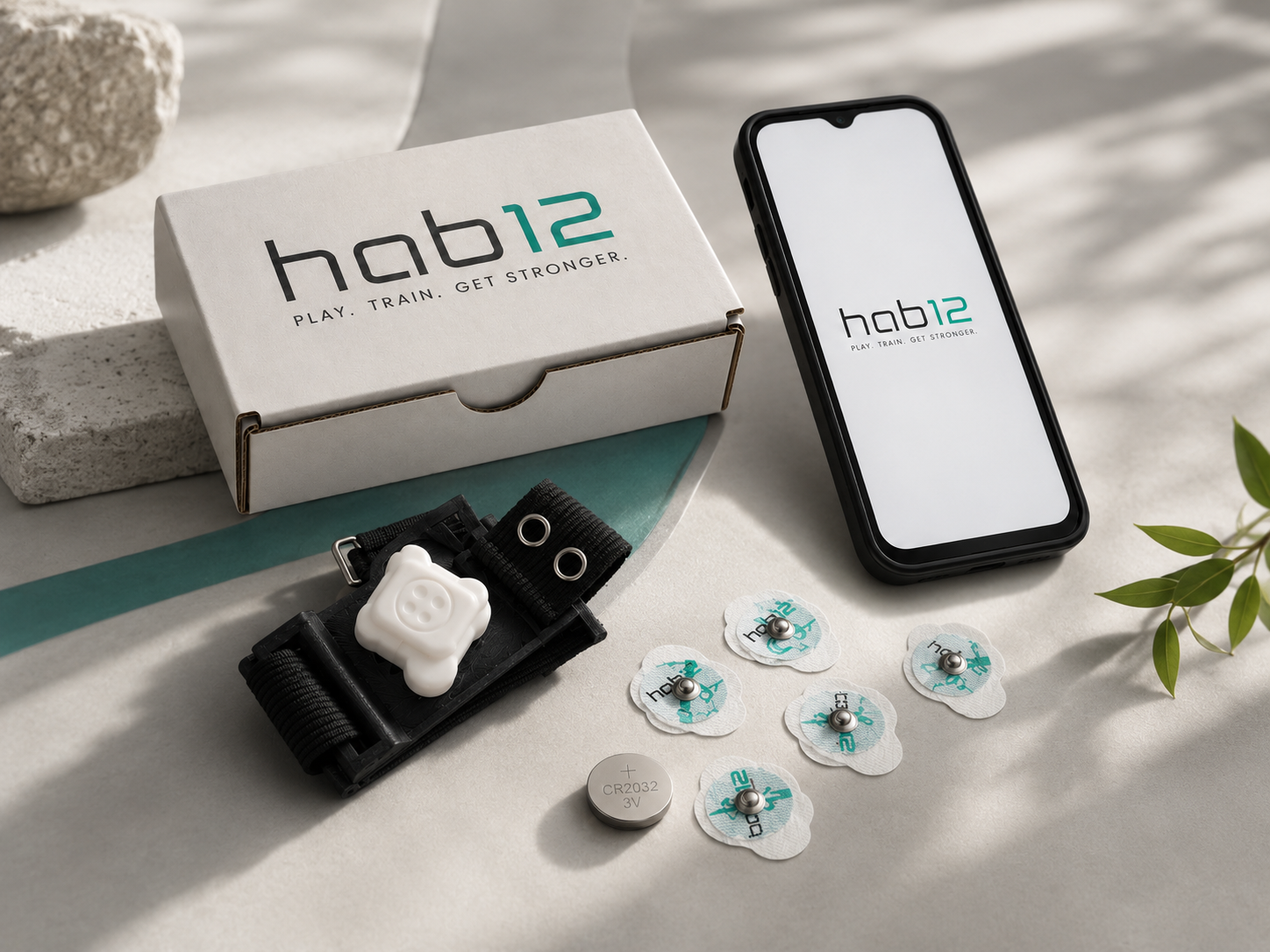 Hab12 wearable, mobile app, electrode accessories, battery, and branded packaging arranged together